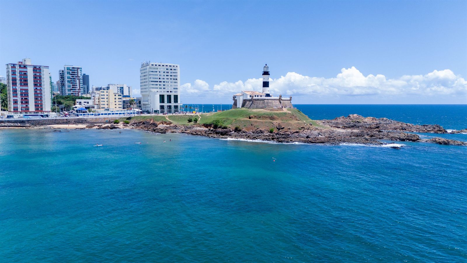Lighthouse fort on a rocky point beside turquoise water in Salvador, Brazil