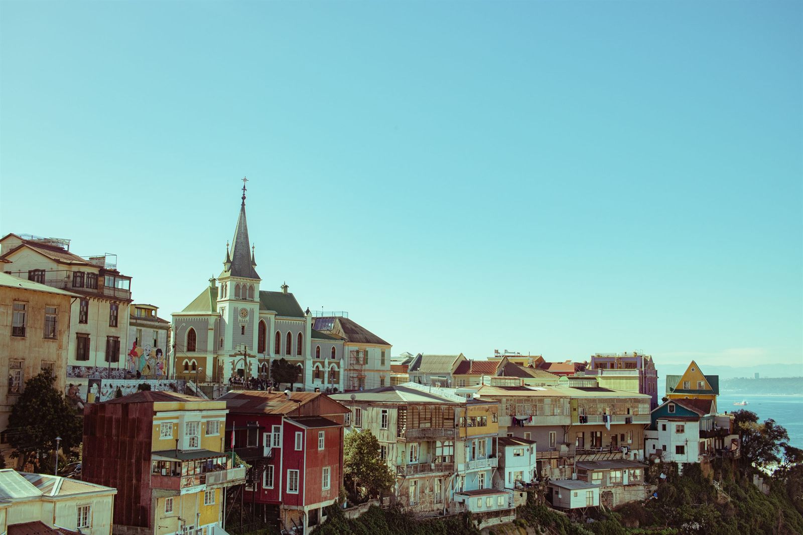 Colorful hillside houses and a church spire above the bay in Valparaiso, Chile