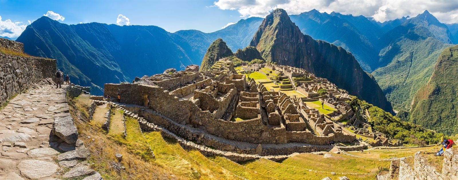 Machu Picchu ruins on a ridge between steep green Andean peaks
