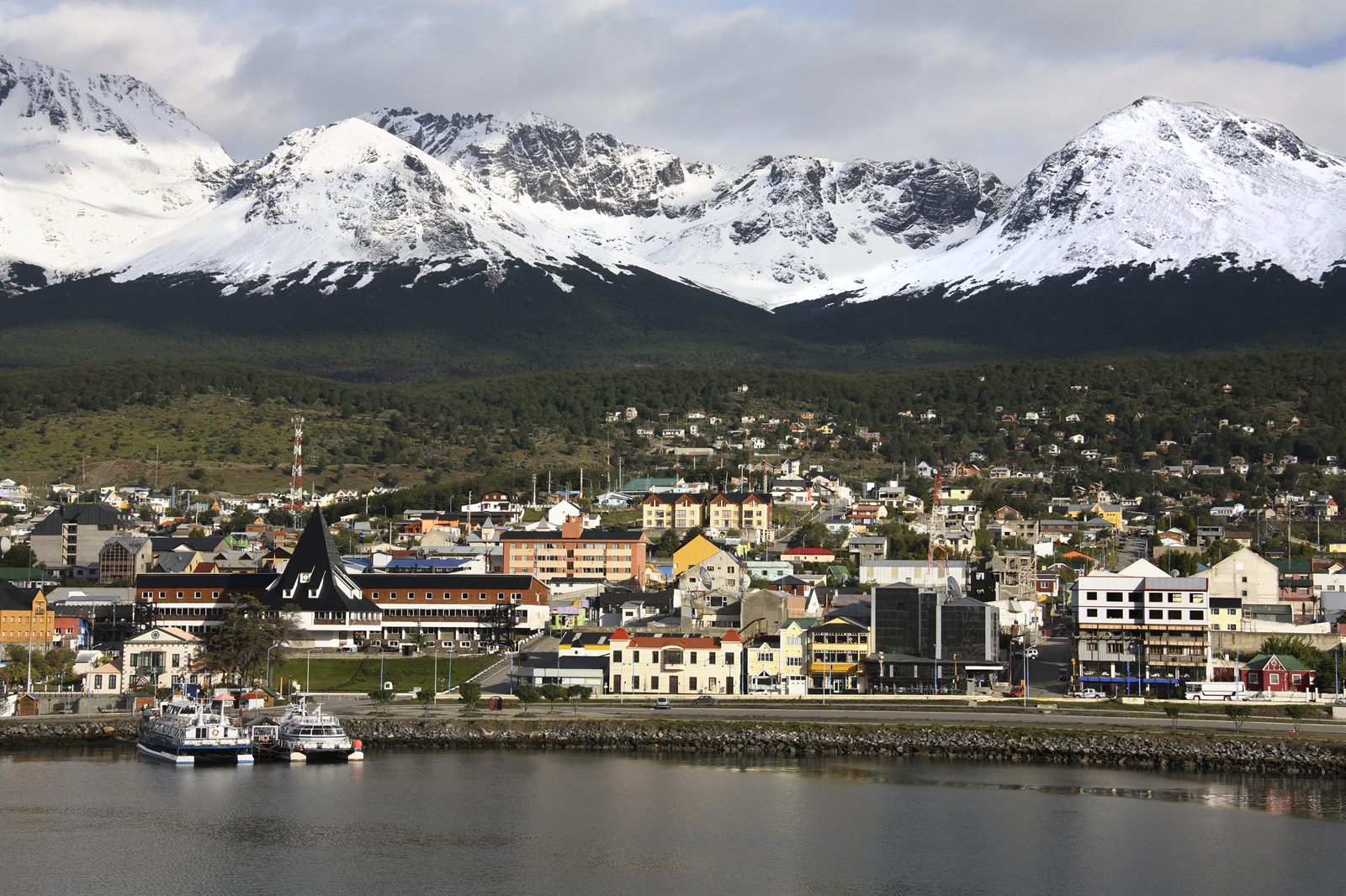 Ushuaia waterfront and harbor below snow-capped mountains in Tierra del Fuego